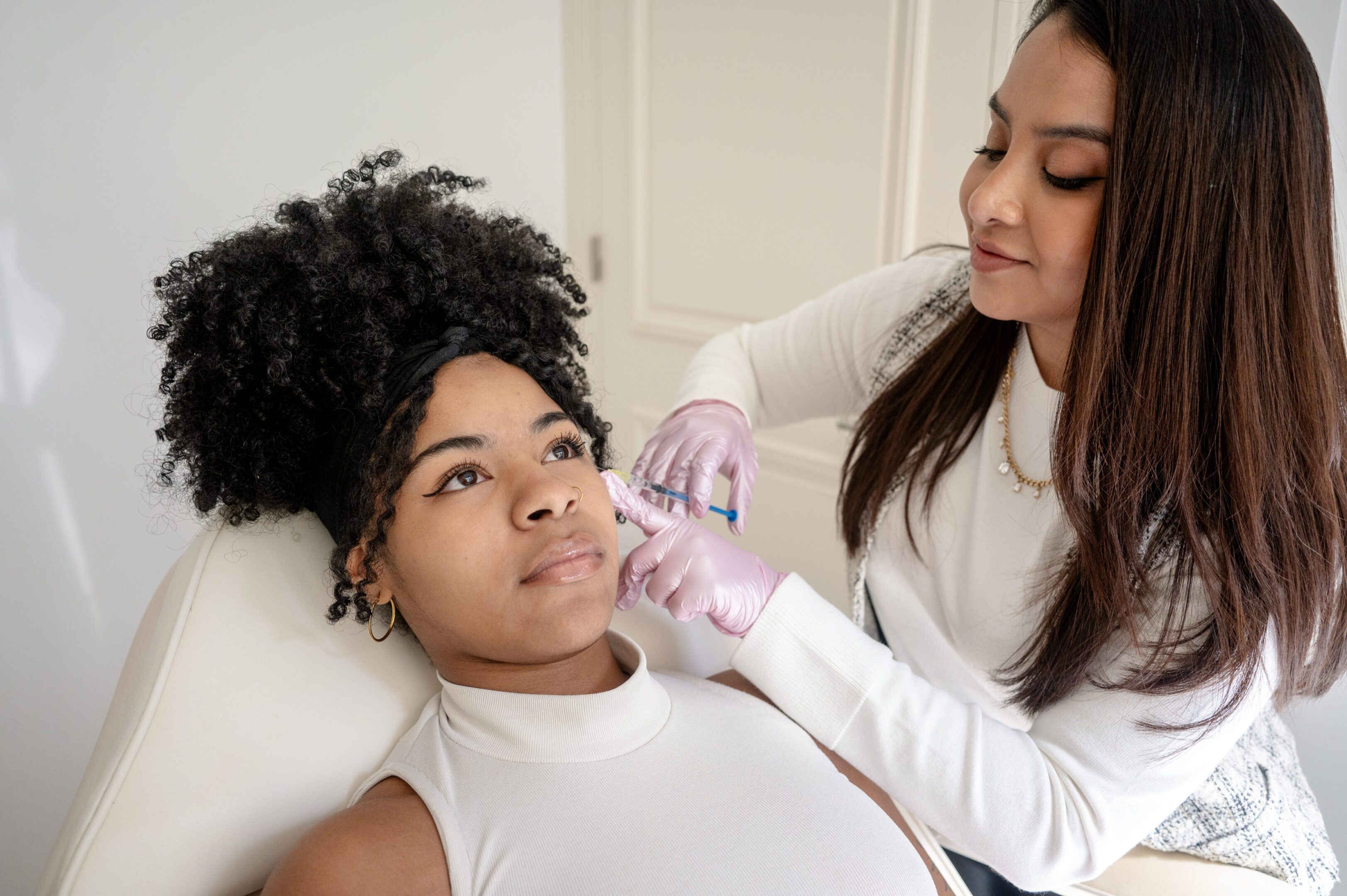 Botox application on lips and brow with a blonde and a black model. Portraits