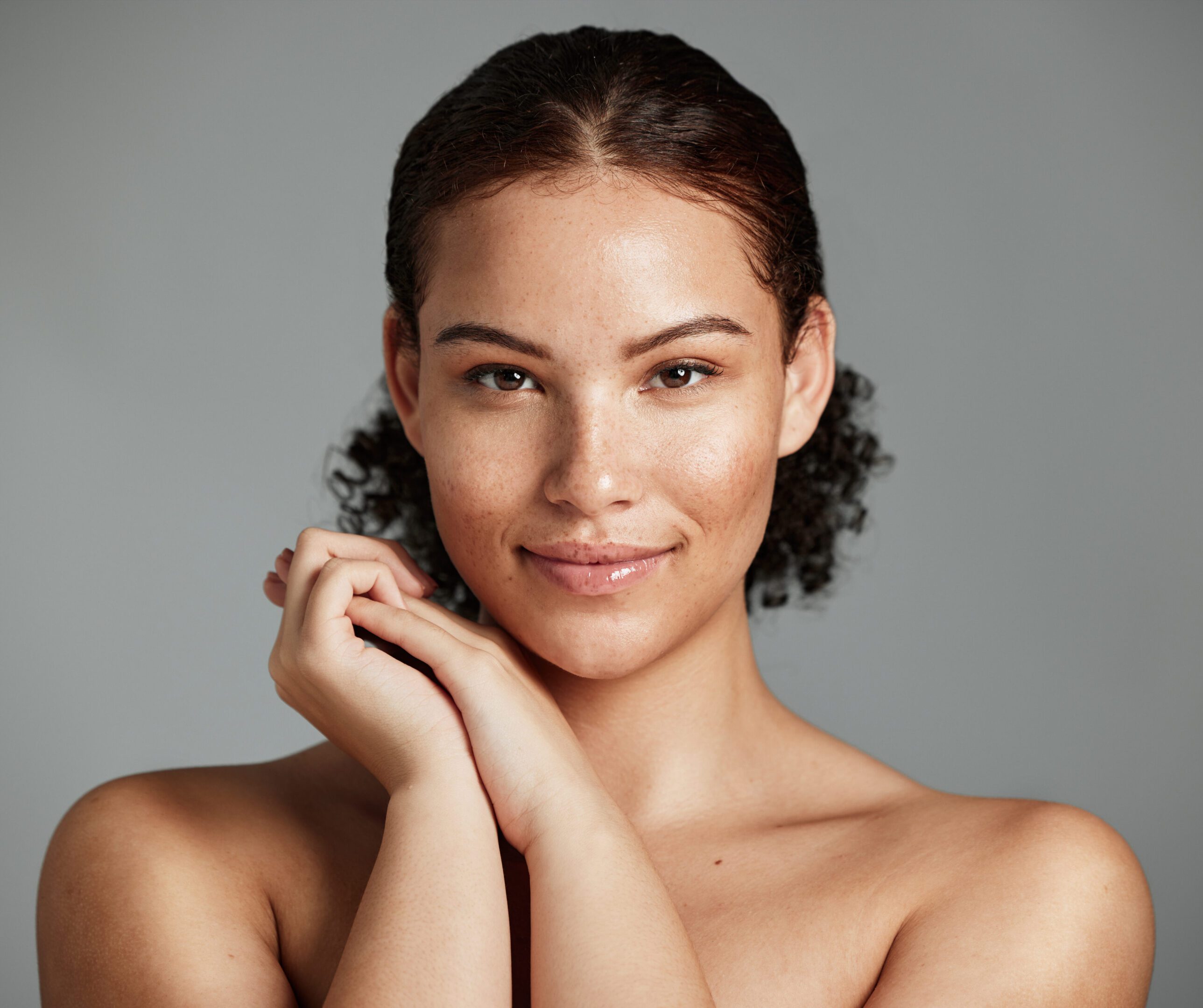 Health, natural and black woman skincare portrait for beauty cosmetic and glow treatment campaign. Healthy body care of model happy with beautiful freckles on face in gray studio background.